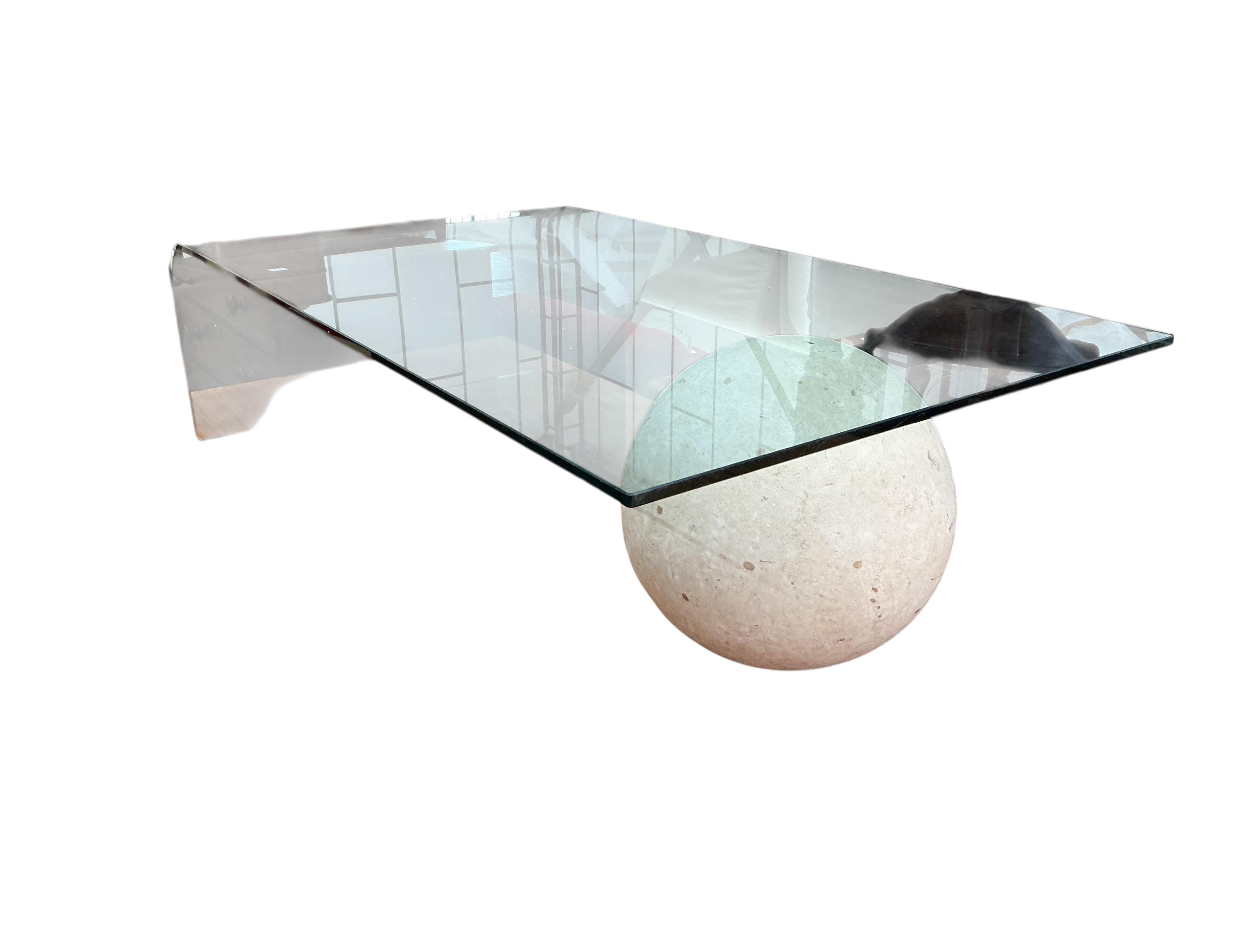 A Contemporary glass top coffee table with faux marble sphere support